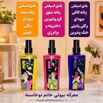 ویژگی های عطر مو و بادی اسپلش کالیستا مدل کیتا در دست با ناخن‌های مشکی در پس‌زمینه گل‌های بنفش و نور آفتاب