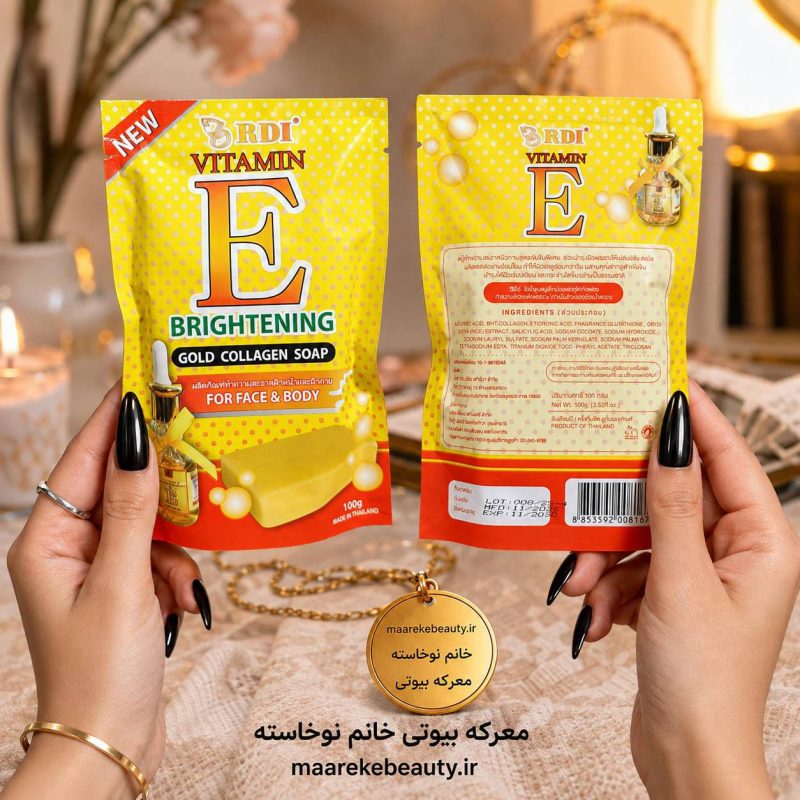 صابون ویتامین E RDI روشن‌کننده طلای کلاژن RDI در دست خانم با ناخن‌های مشکی کشیده، با نمایش واضح بسته‌بندی و نوشته‌های محصول، روی پس‌زمینه گرم و روشن پینترستی.